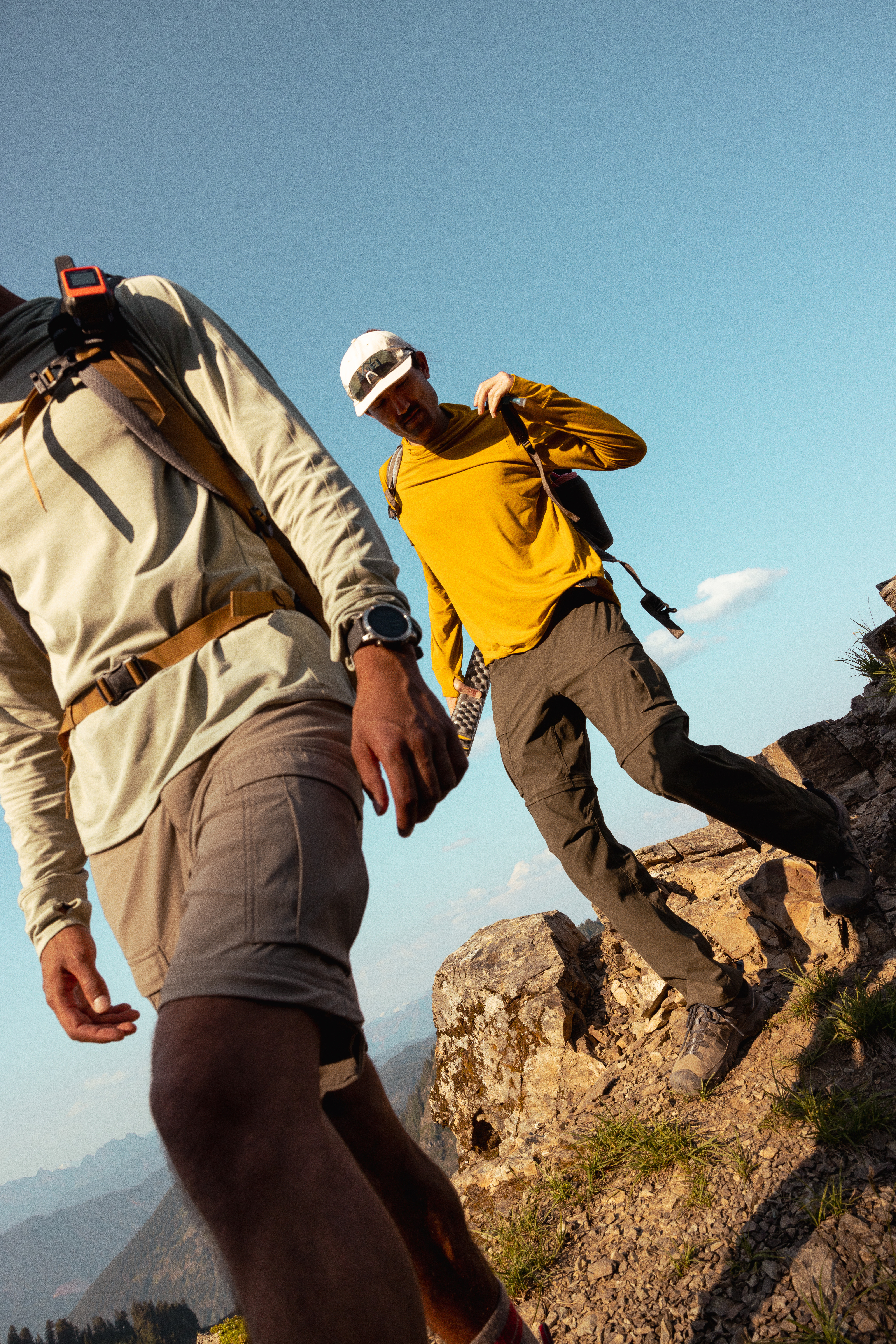 Two hikers on a trail in R E I gear.