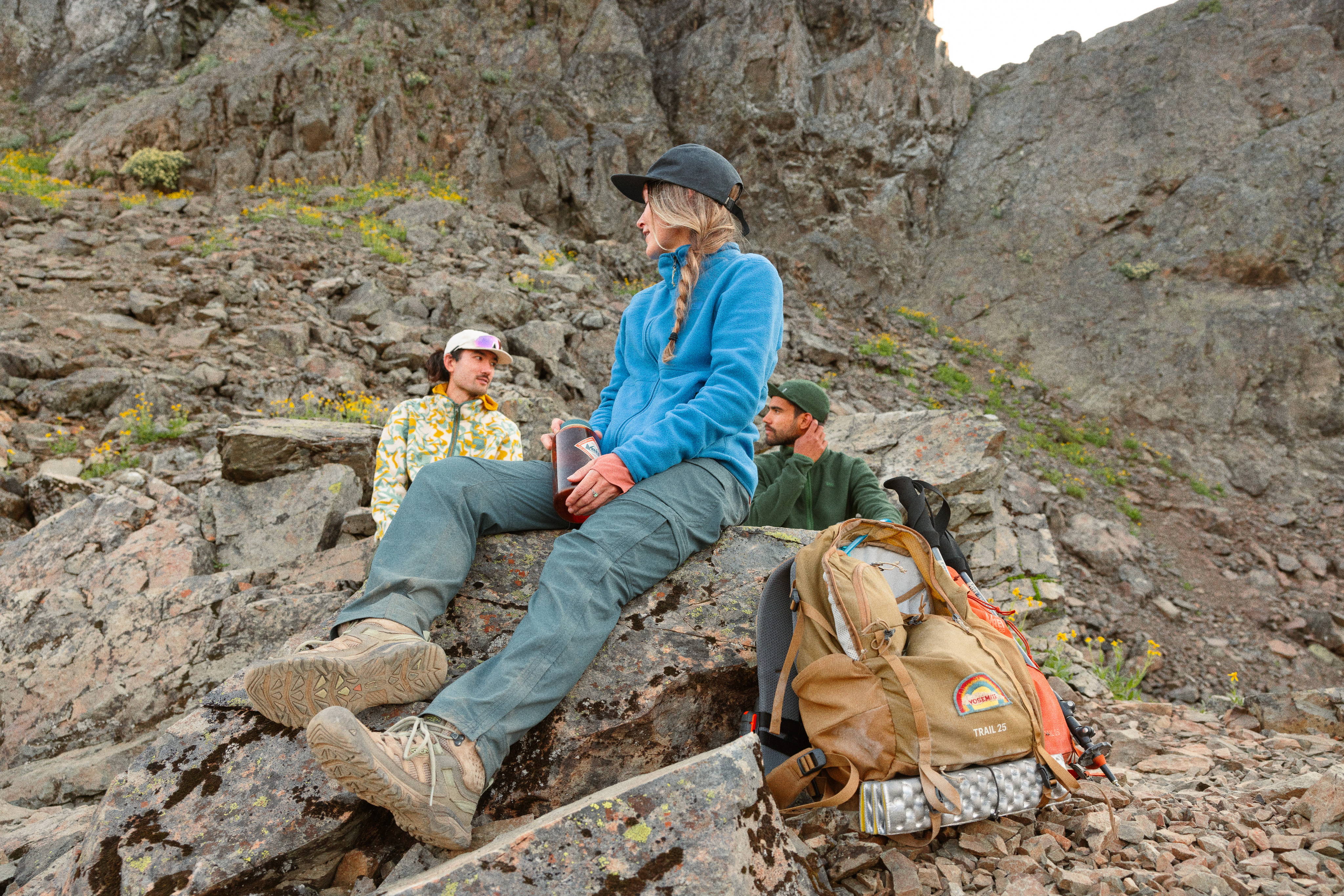 Hikers in cozy fleece jackets taking a water break on a trail.