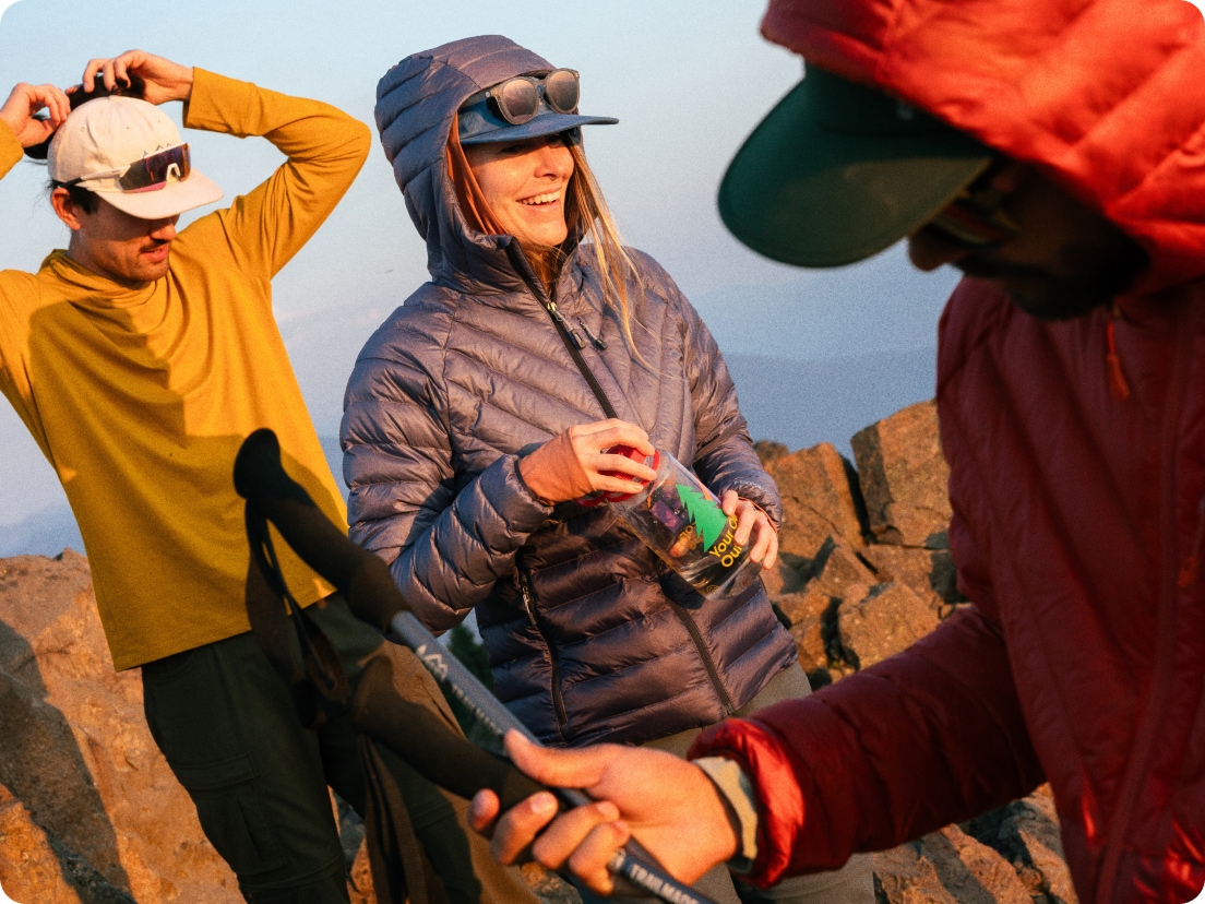 A group of explorers at the top of a trail on a cool, sunny day.