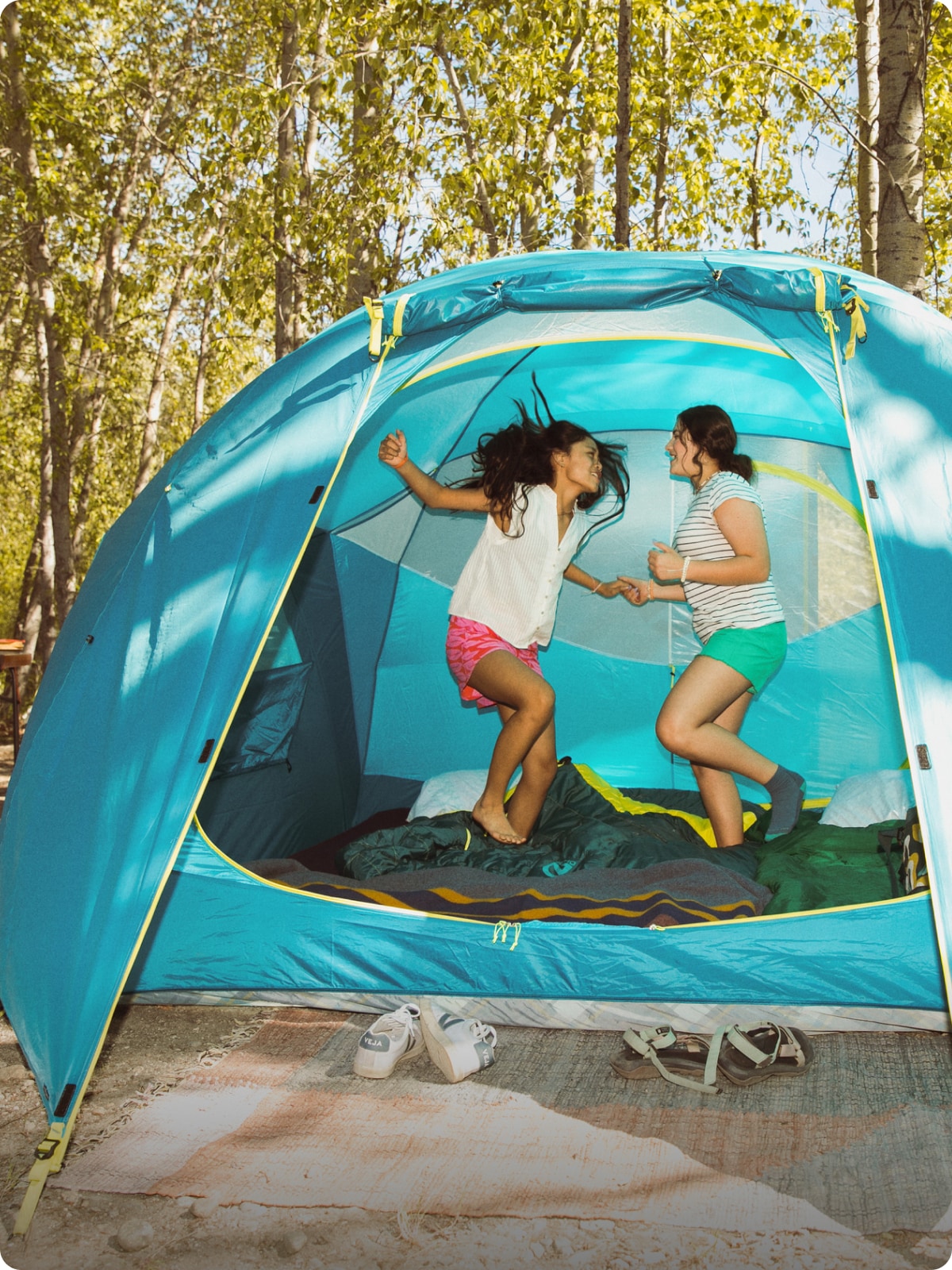 Two people dancing in a tent in the forest.