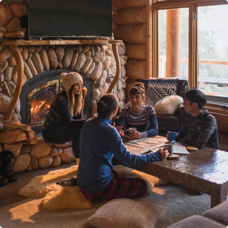 A group of friends enjoying warm drinks by the chimney fire.