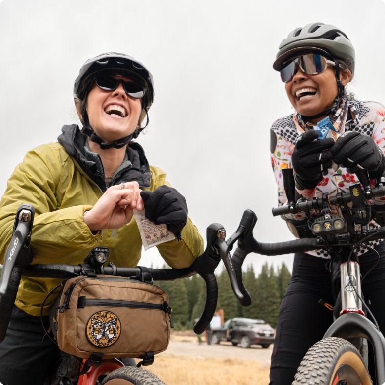 Two people taking a break from biking to enjoy a snack.