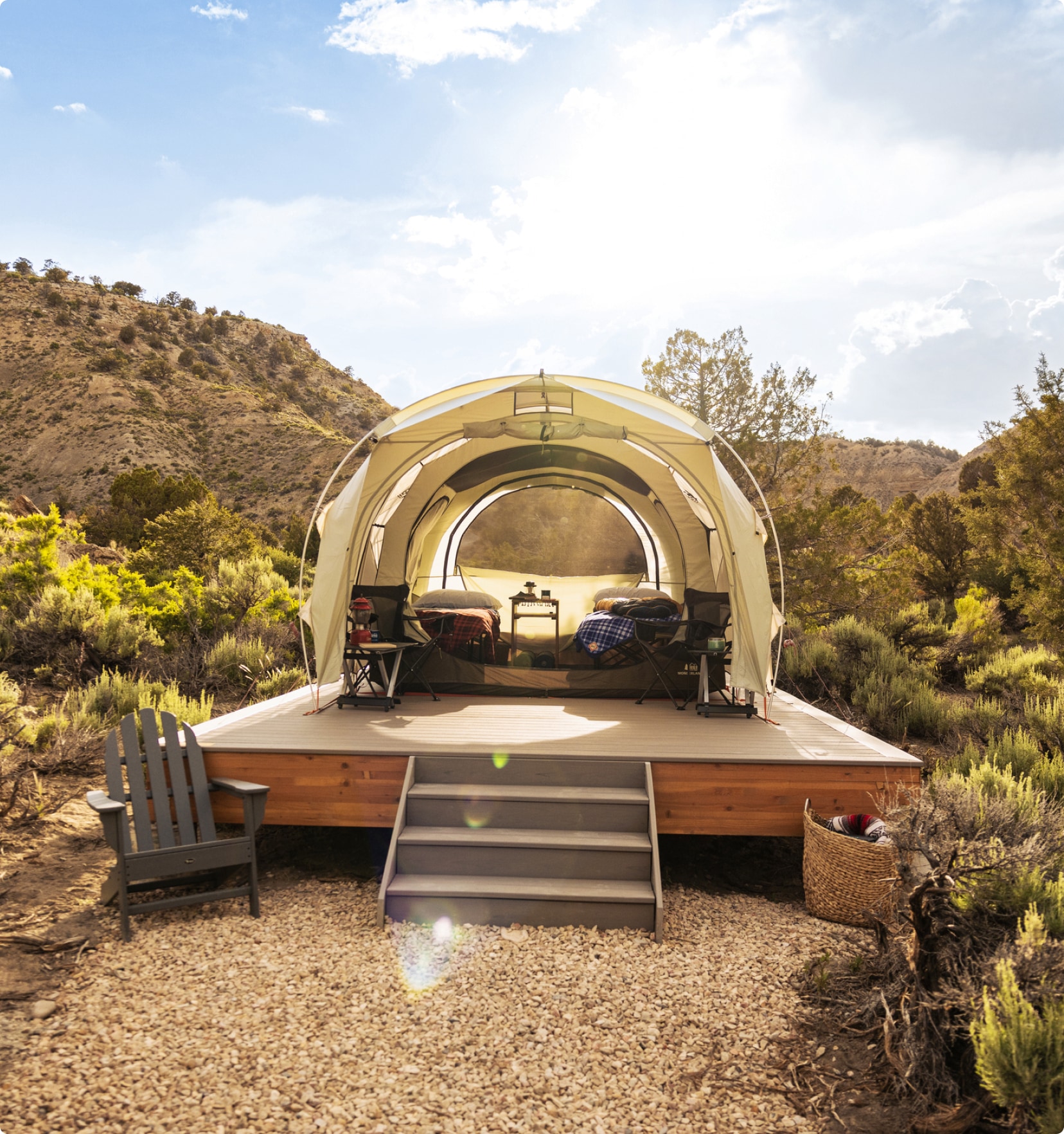 An open tent on a platform in front of the mountains.