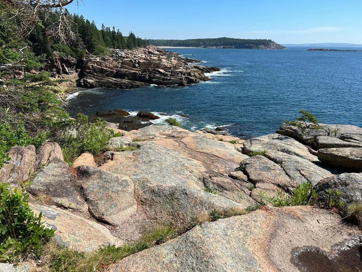 We cycle along rocky coastline and rose-colored granite mountains.