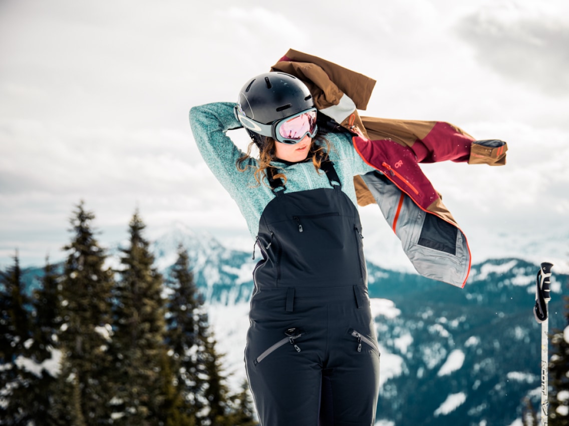 A person putting on a snow jacket.