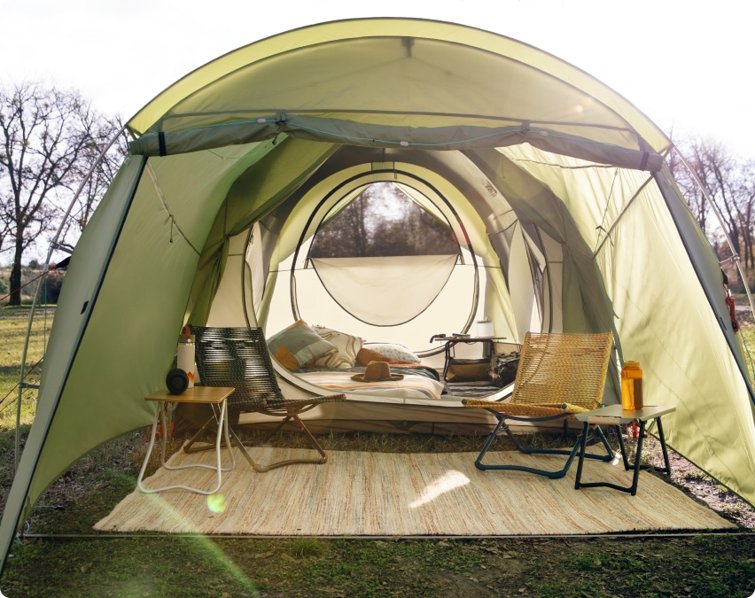 An REI camping tent set up outdoors, fully stocked with essential camping gear.