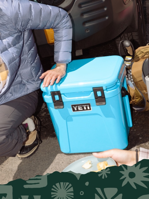 Campers sit next to a YETI cooler.