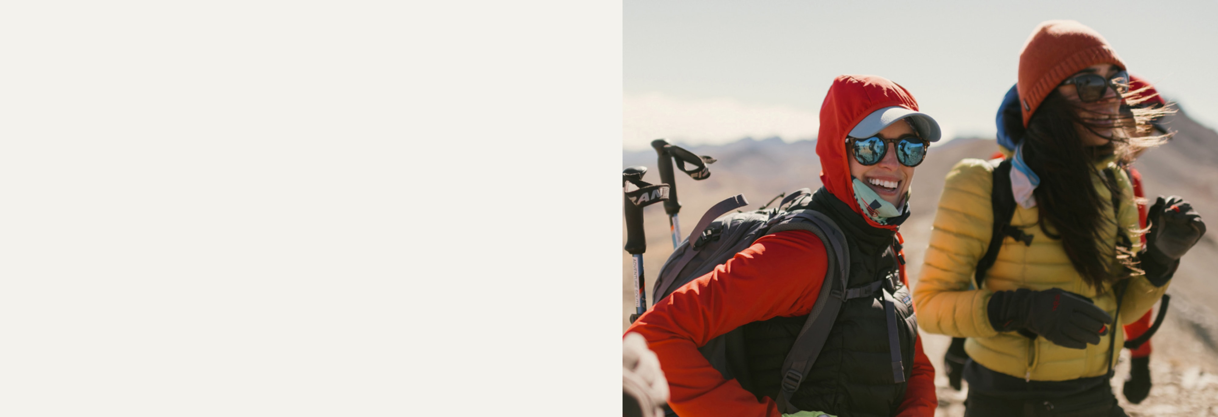 Hikers in colorful outdoor gear smile from a lookout spot.