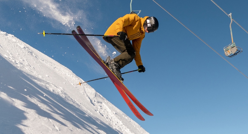 A skier mid-jump on a bluebird day.