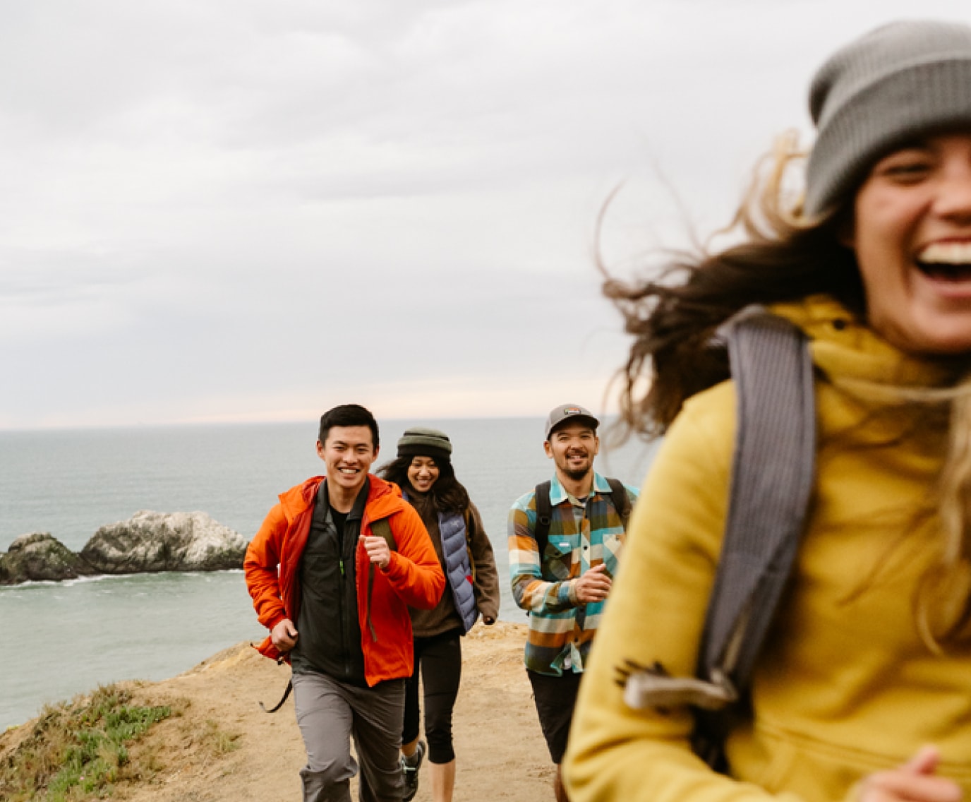 Hikers laughing on a coastal trail.