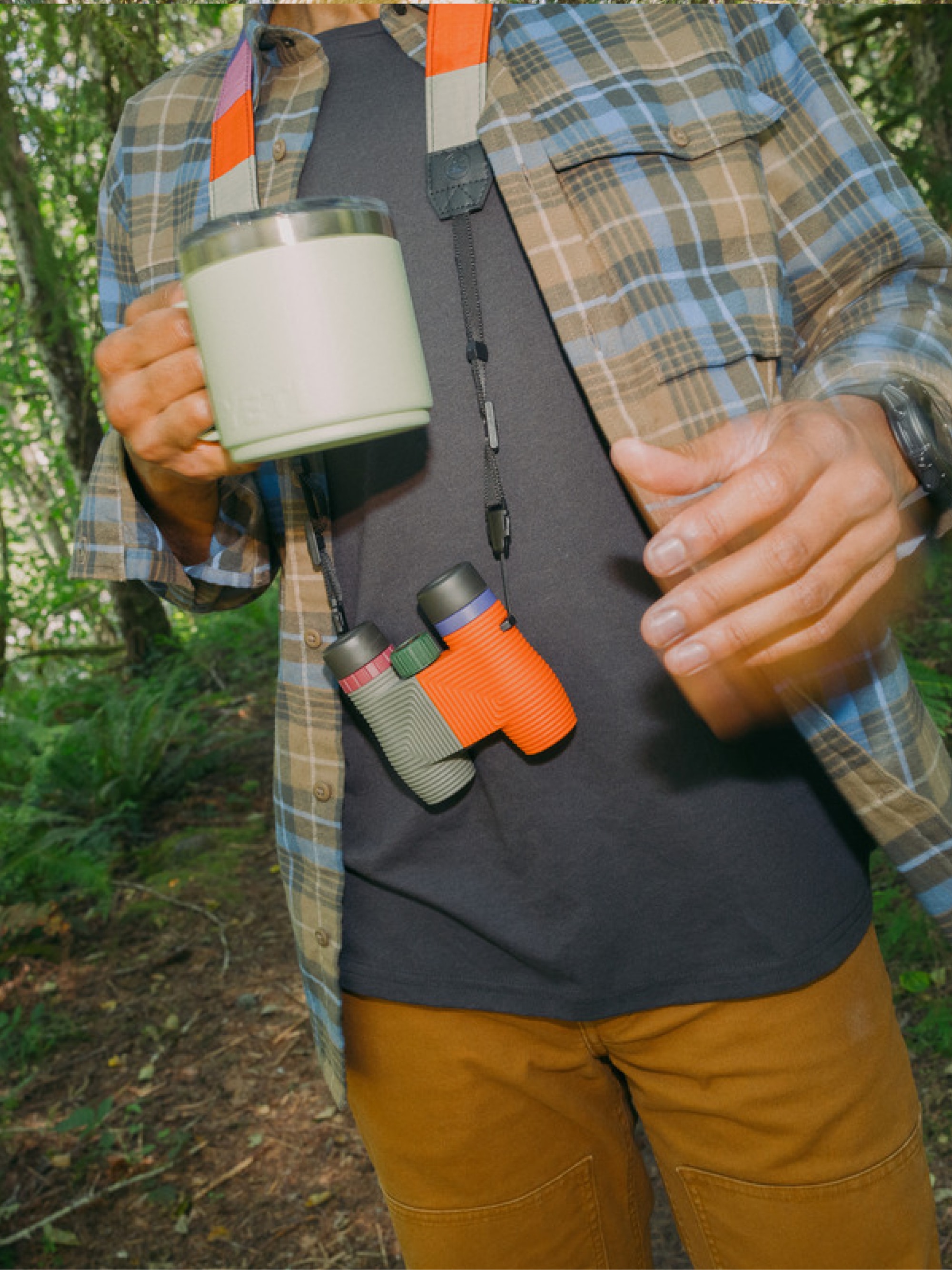 A camper holds an R E I Co-op mug.