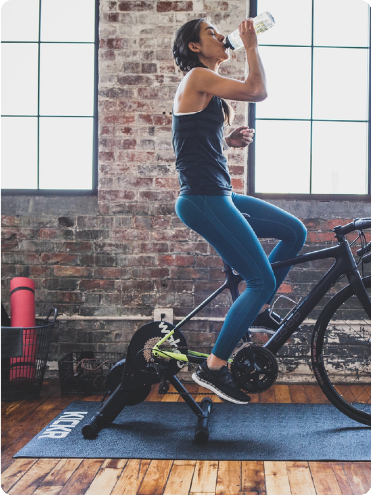 A person takes a water break on a stationary bike.