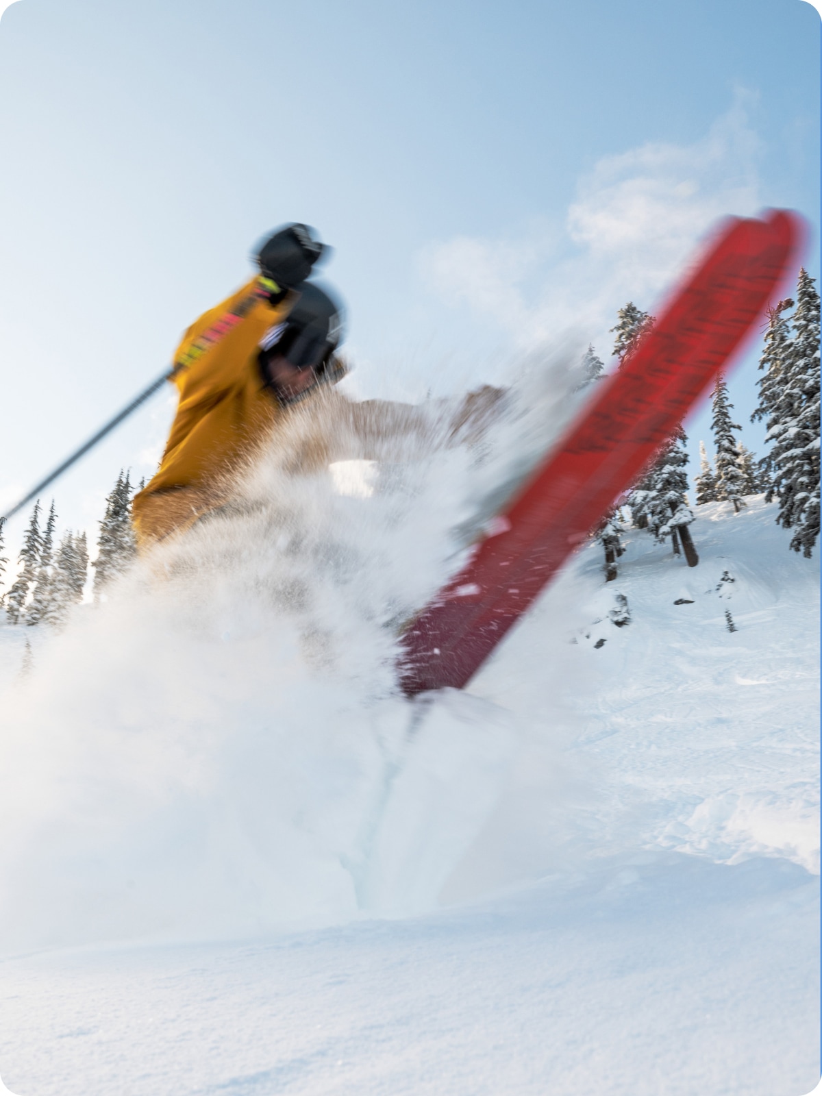 A skier kicks up a wave of powder.