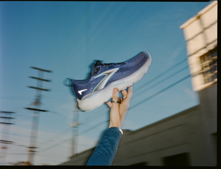 A running holding up a single Brooks Glycerin 22 road-running shoe