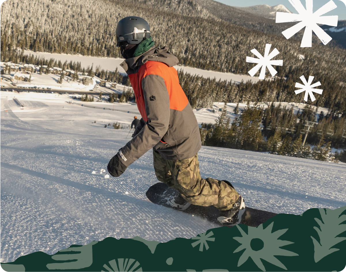 A snowboarder carves down a mountain.