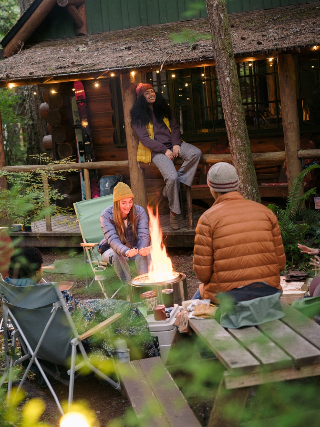 Campers enjoy a campfire outside their cabin.