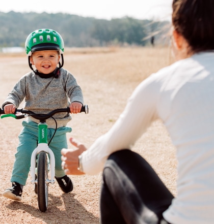 A small child enjoys a ride on their woom bike.