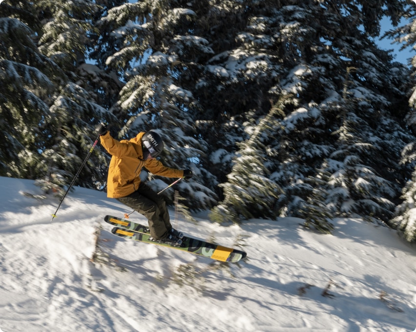 A skier zips downhill on their skis while wearing a Smith snow helmet.