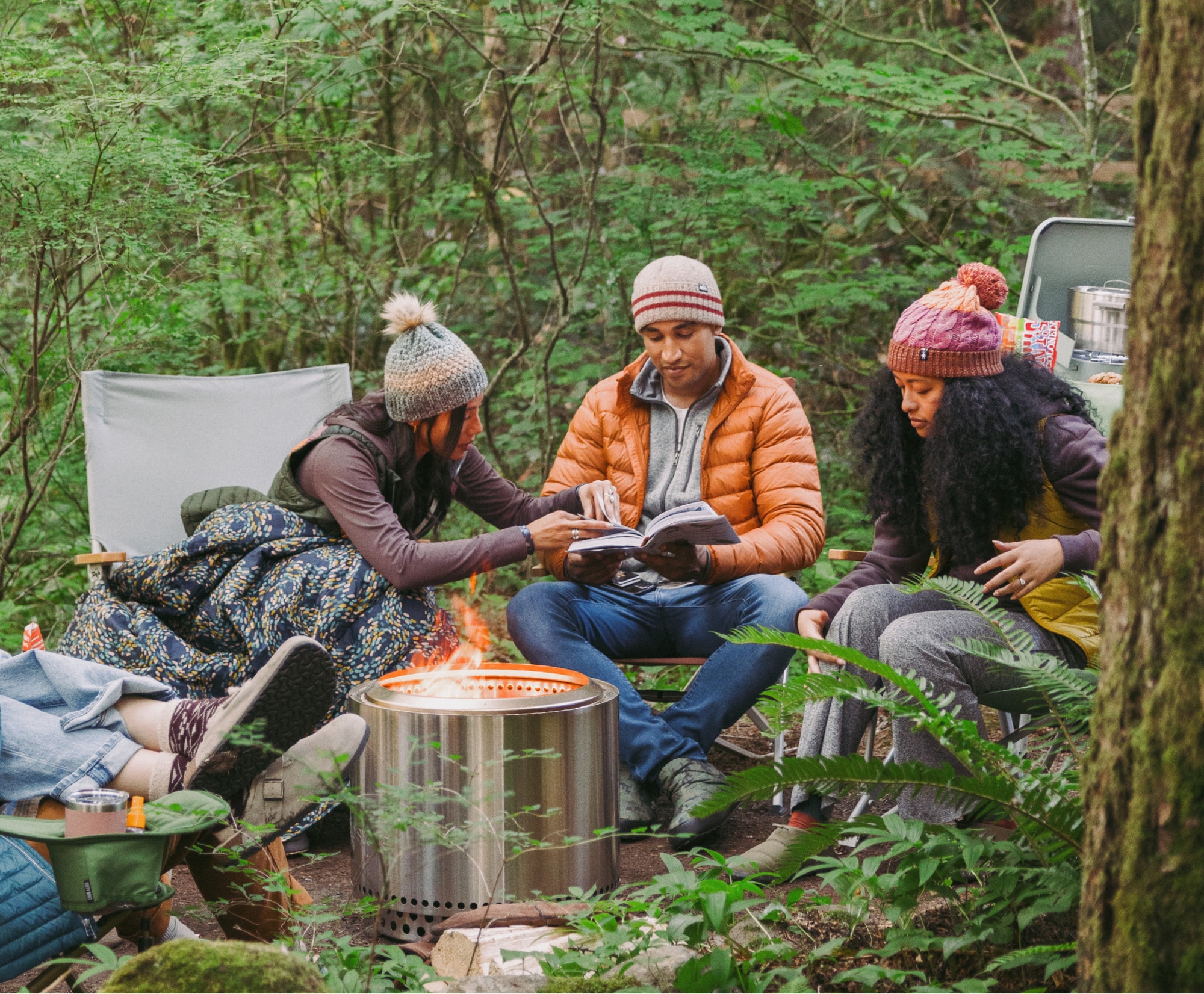 Campers relaxing around a fire pit.