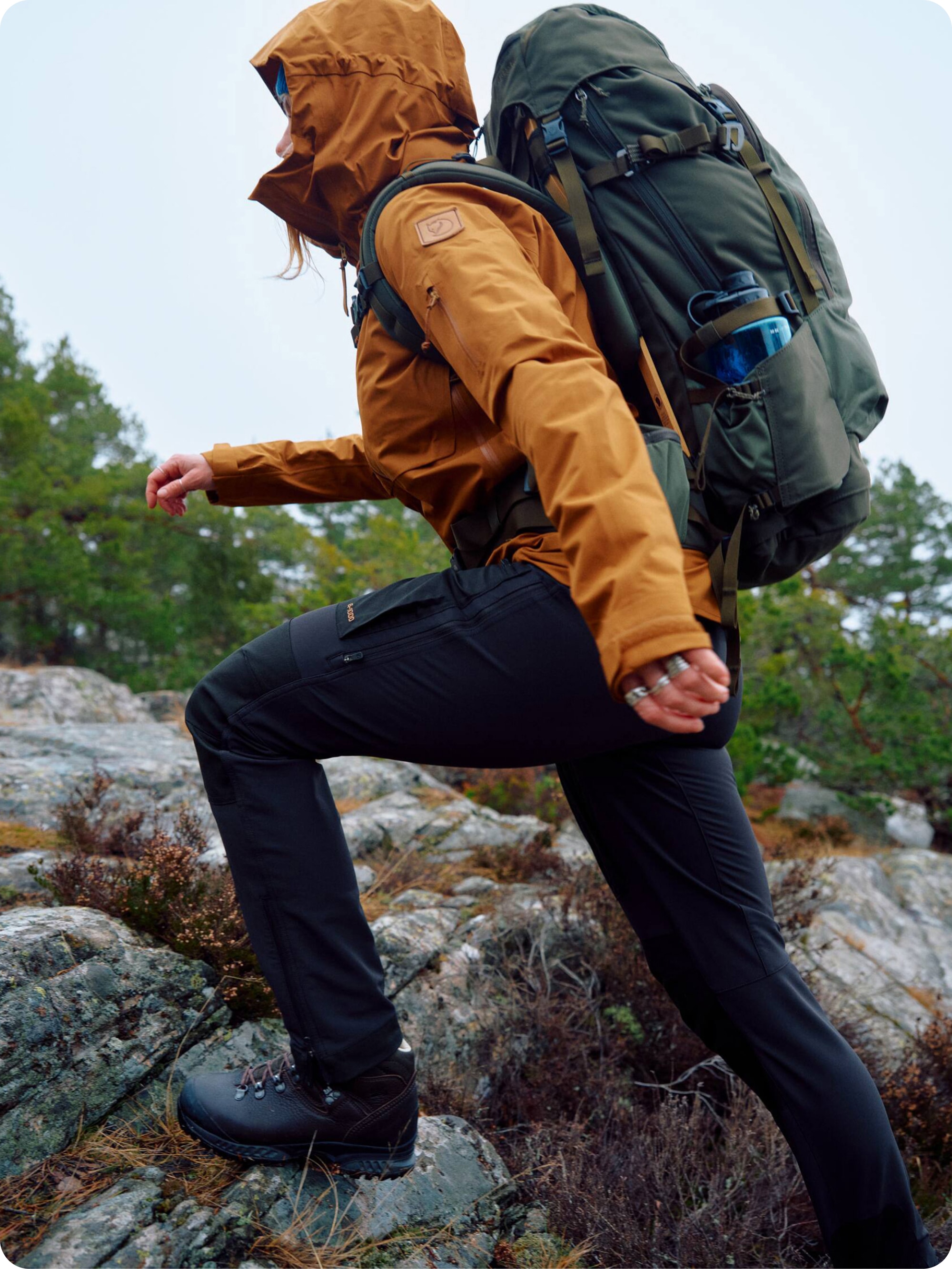 A hiker wears a Fjallraven jacket while making their way up a rocky path.