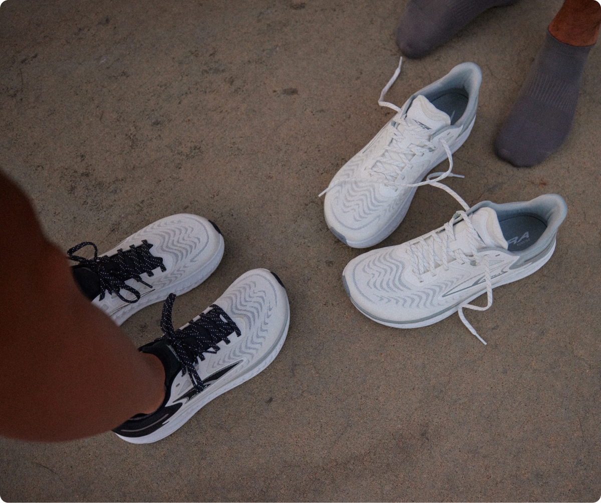 Two pairs of Altra running shoes in the color white.