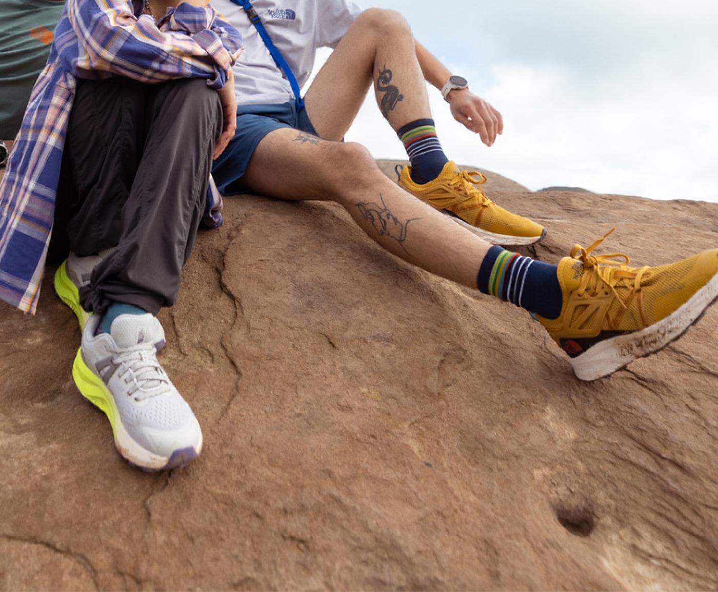 Hikers sitting on top of a rock in their North Face hiking shoes.