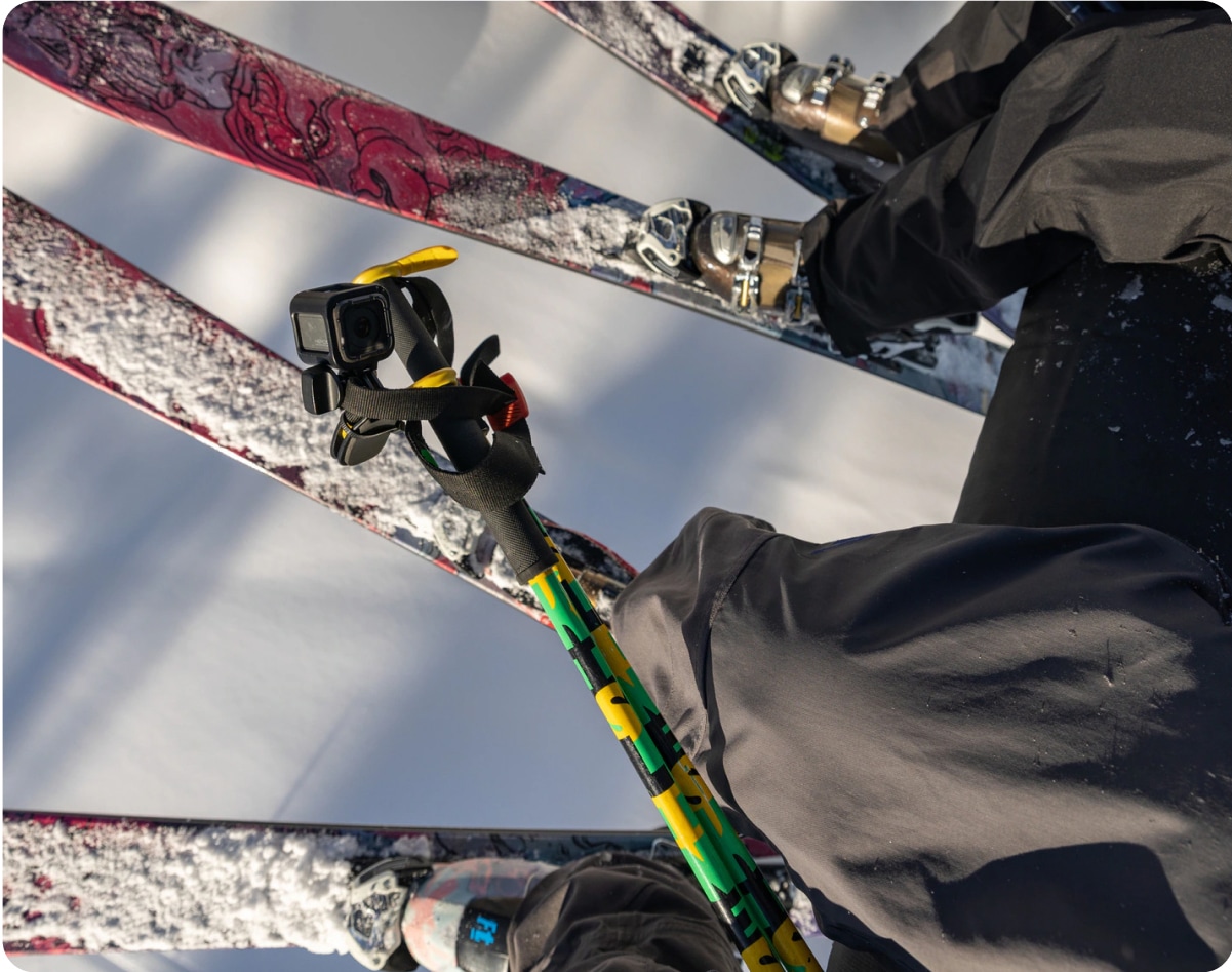 Two pairs of skis and a ski pole with an action camera attached to it.