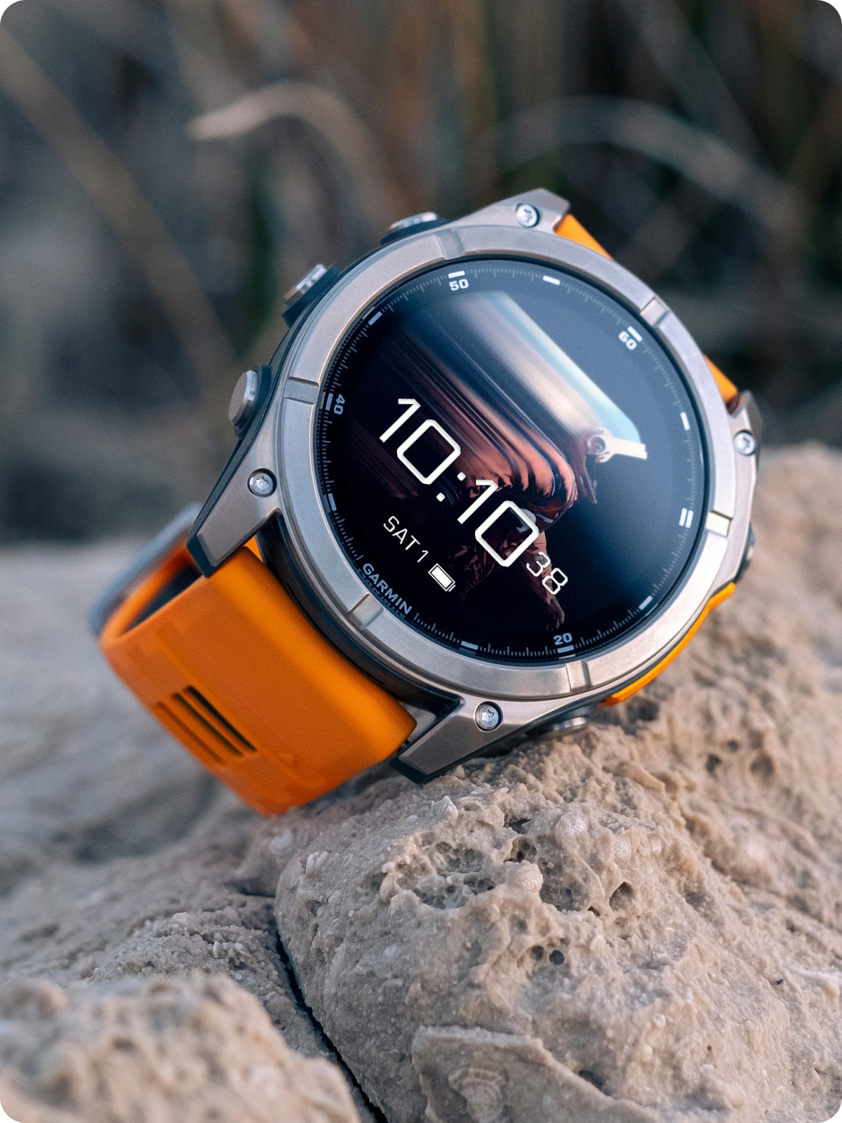 A Garmin watch photographed on top of a rock.