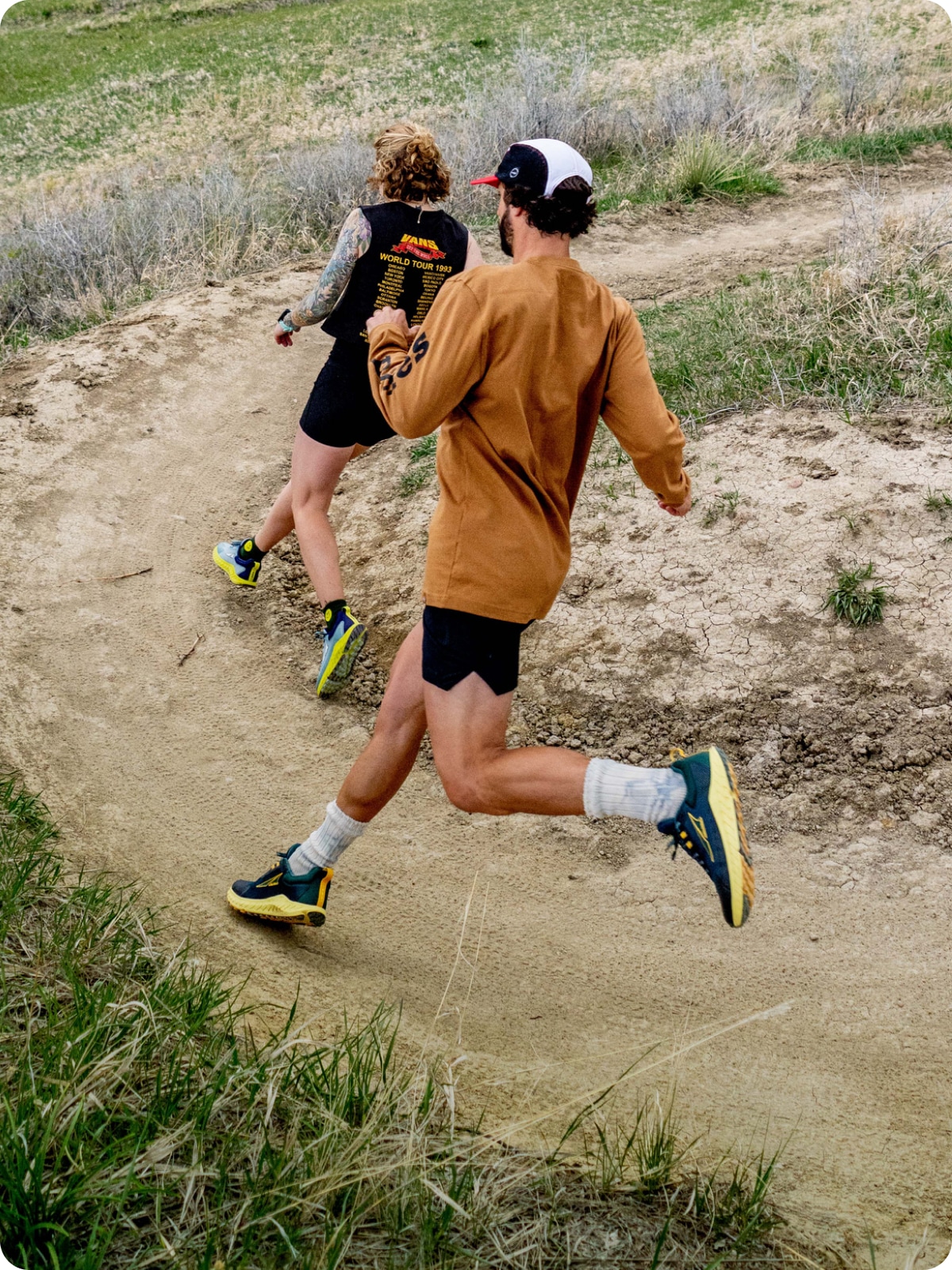 Two trail runners rounding a corner in their Altra shoes.