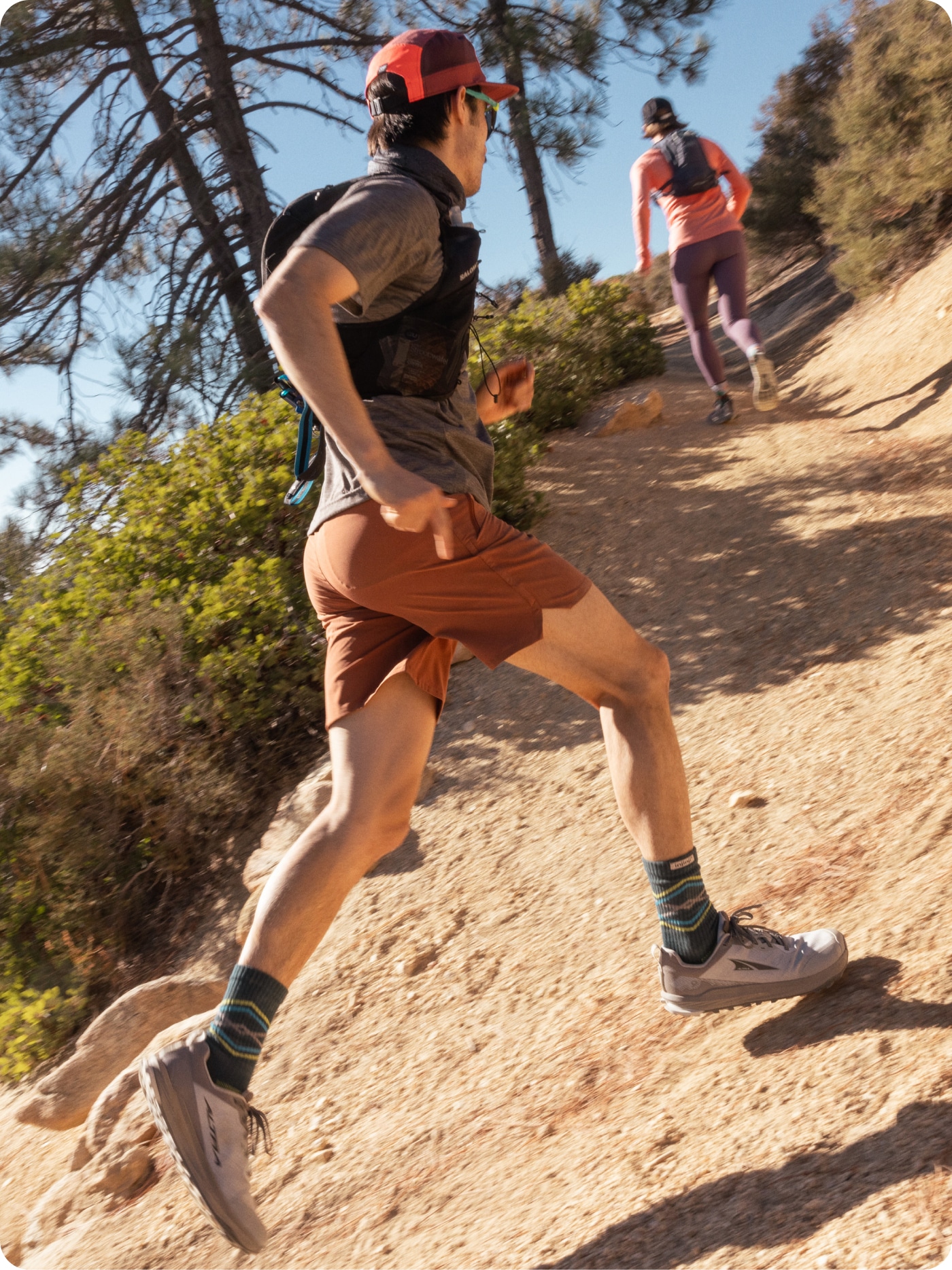 A trail runner speeds up a rocky path in their Altra shoes.