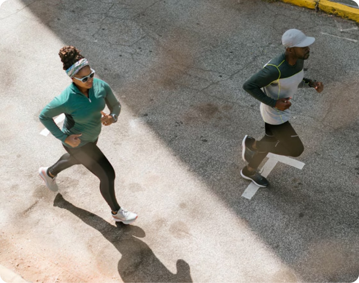 Two people running on the street.