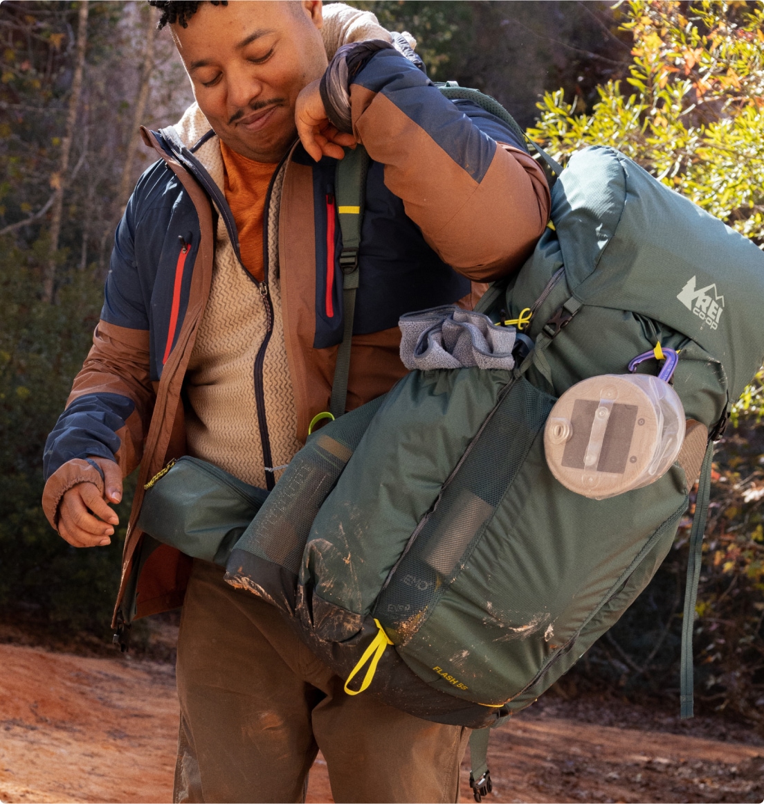 A person picks up their R E I Co-op hiking pack.