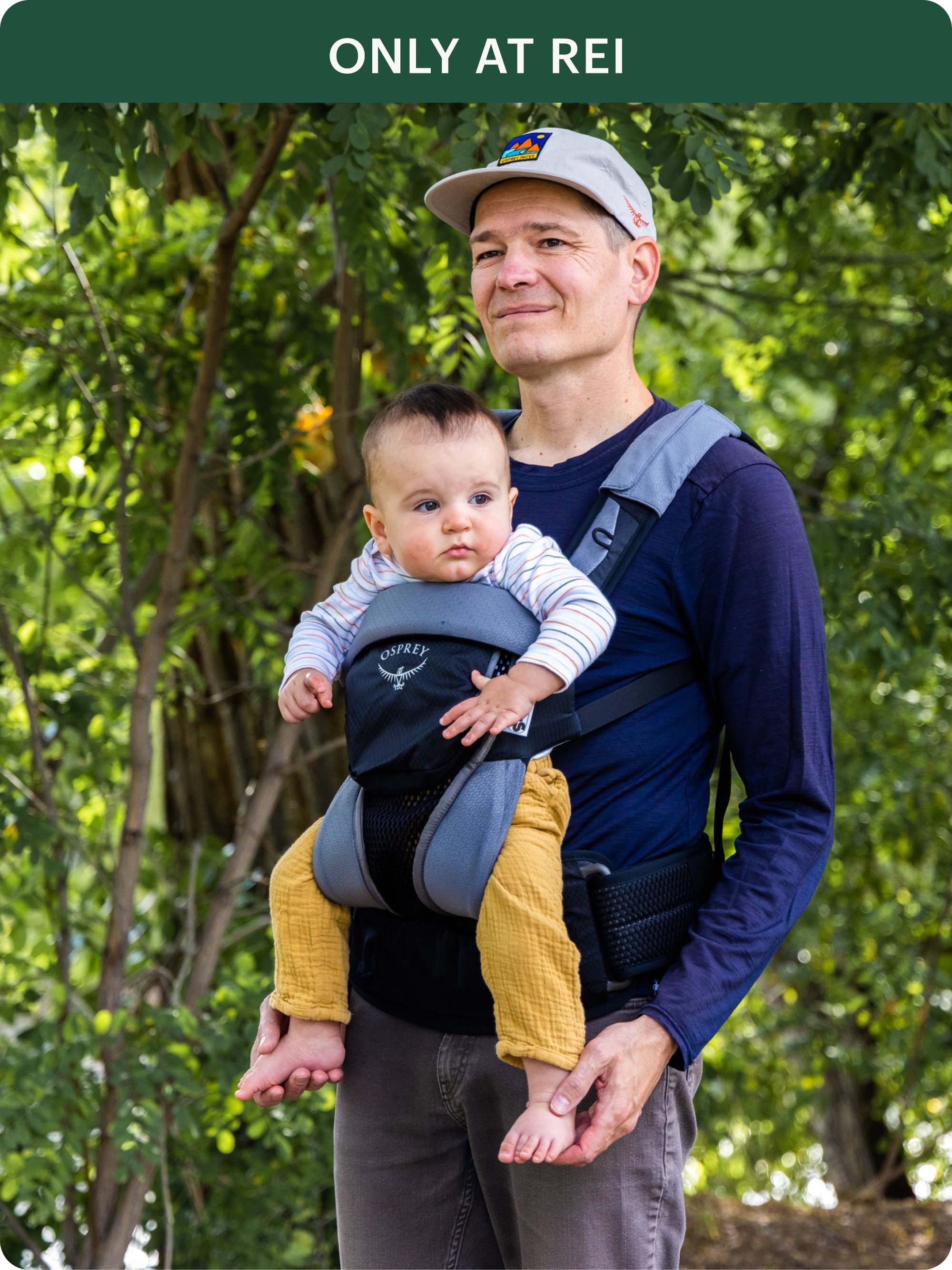 A person enjoys a forest walk with a baby in an Osprey carrier.