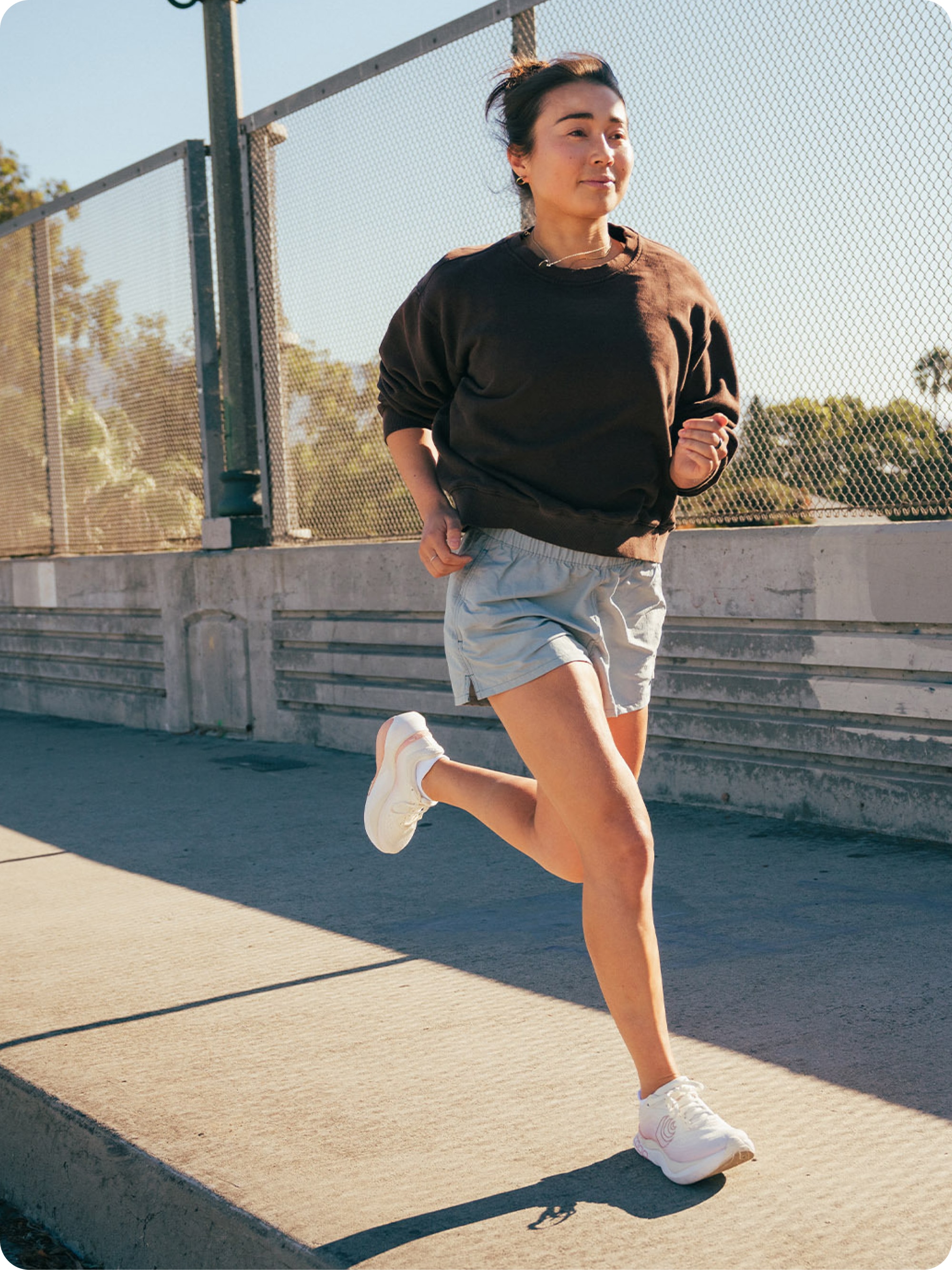 A person runs across a city bridge.