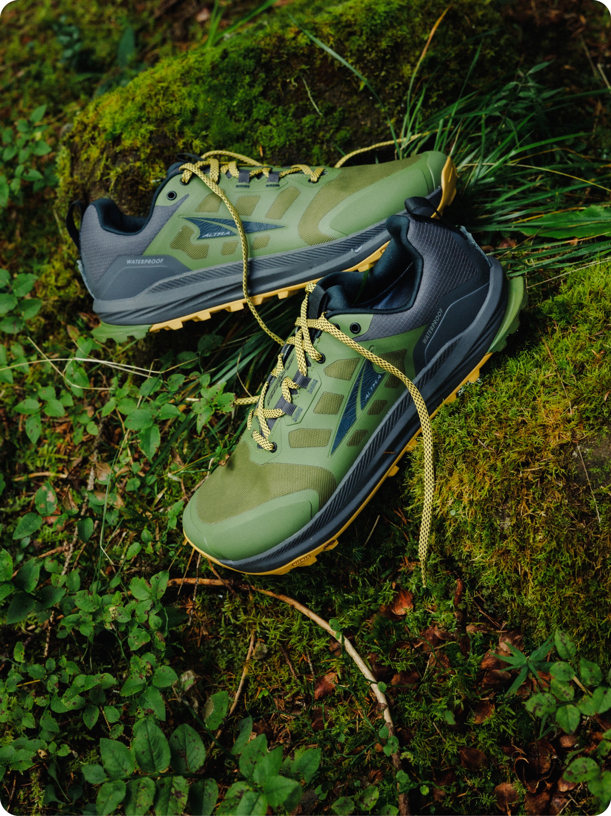 A pair of Altra Lone Peak 9 hiking shoes set on a grassy background.