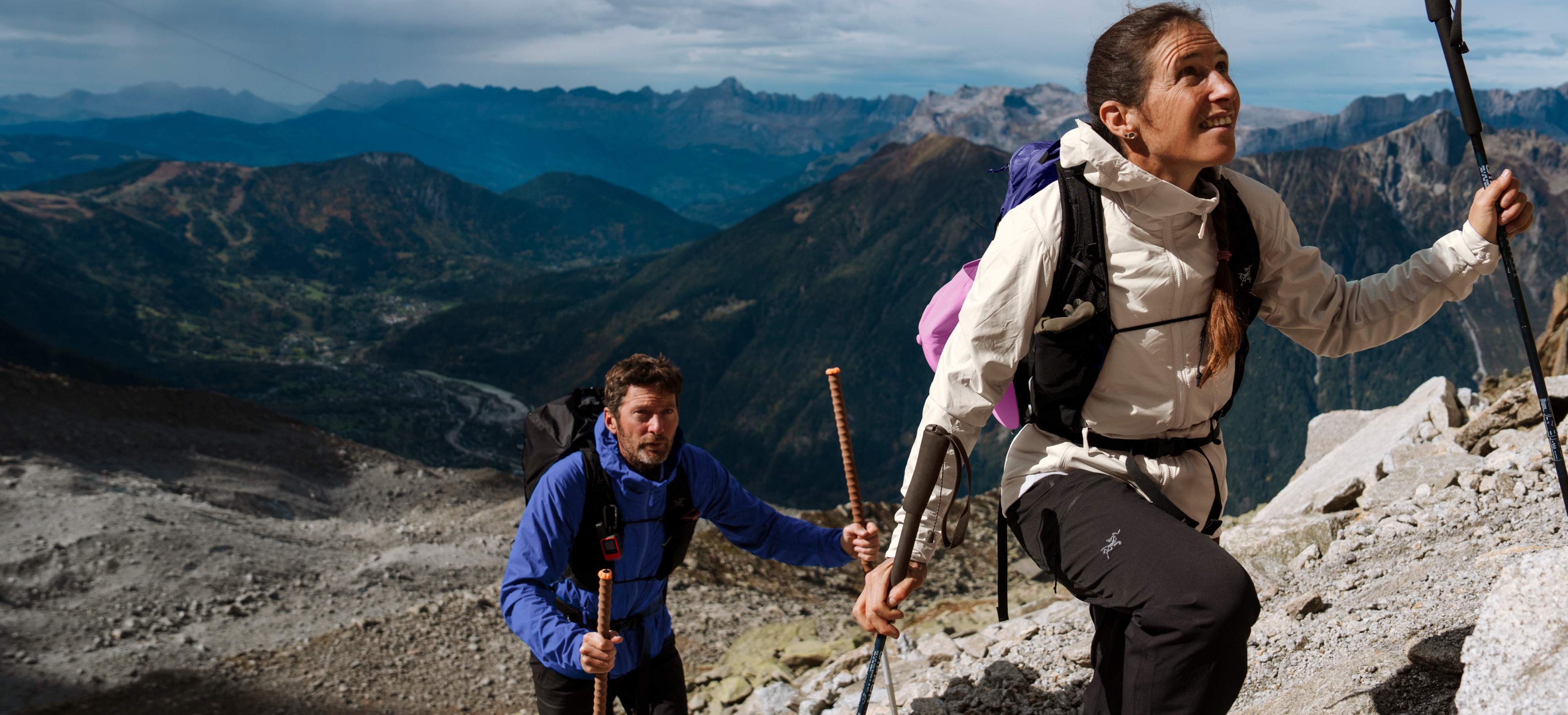 Two people trek up a mountain in Arc’teryx gear. 