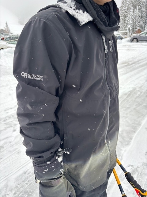 A person wearing a jacket in a snowy background