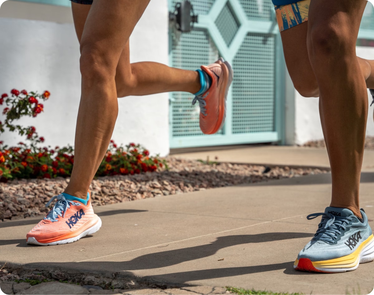 Two people running together in HOKA shoes.