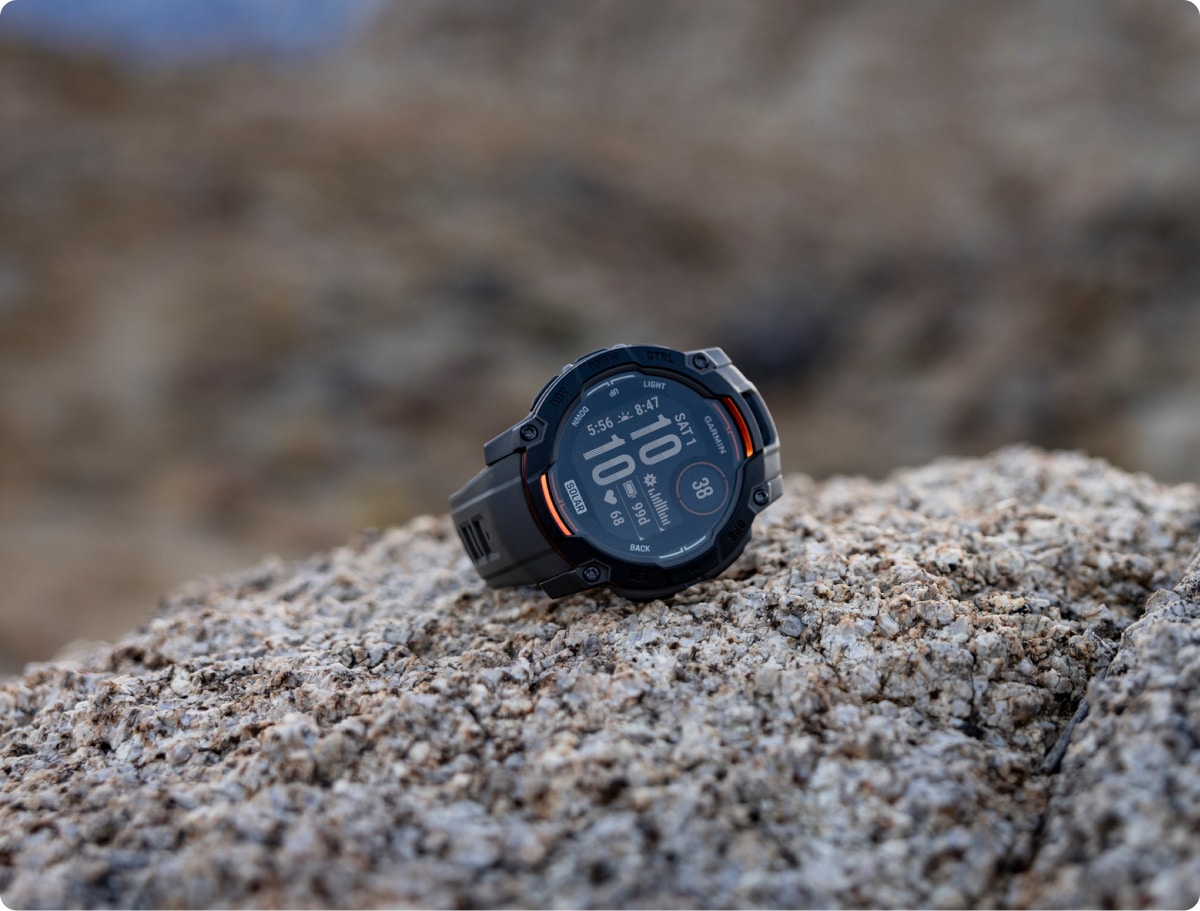 The Garmin Instinct 3 Solar sitting on top of a rock.