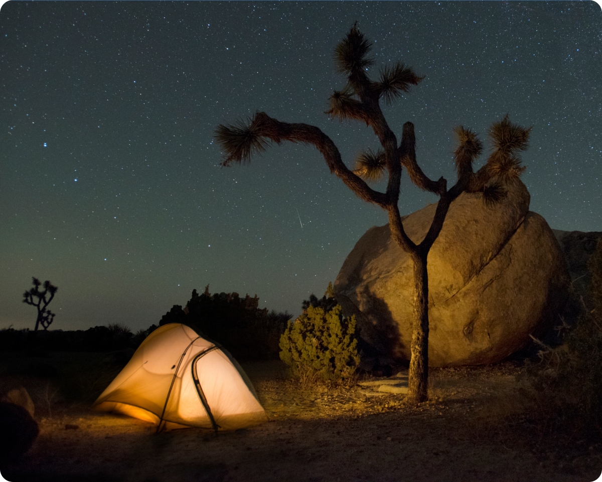 An illuminated tent in the desert.