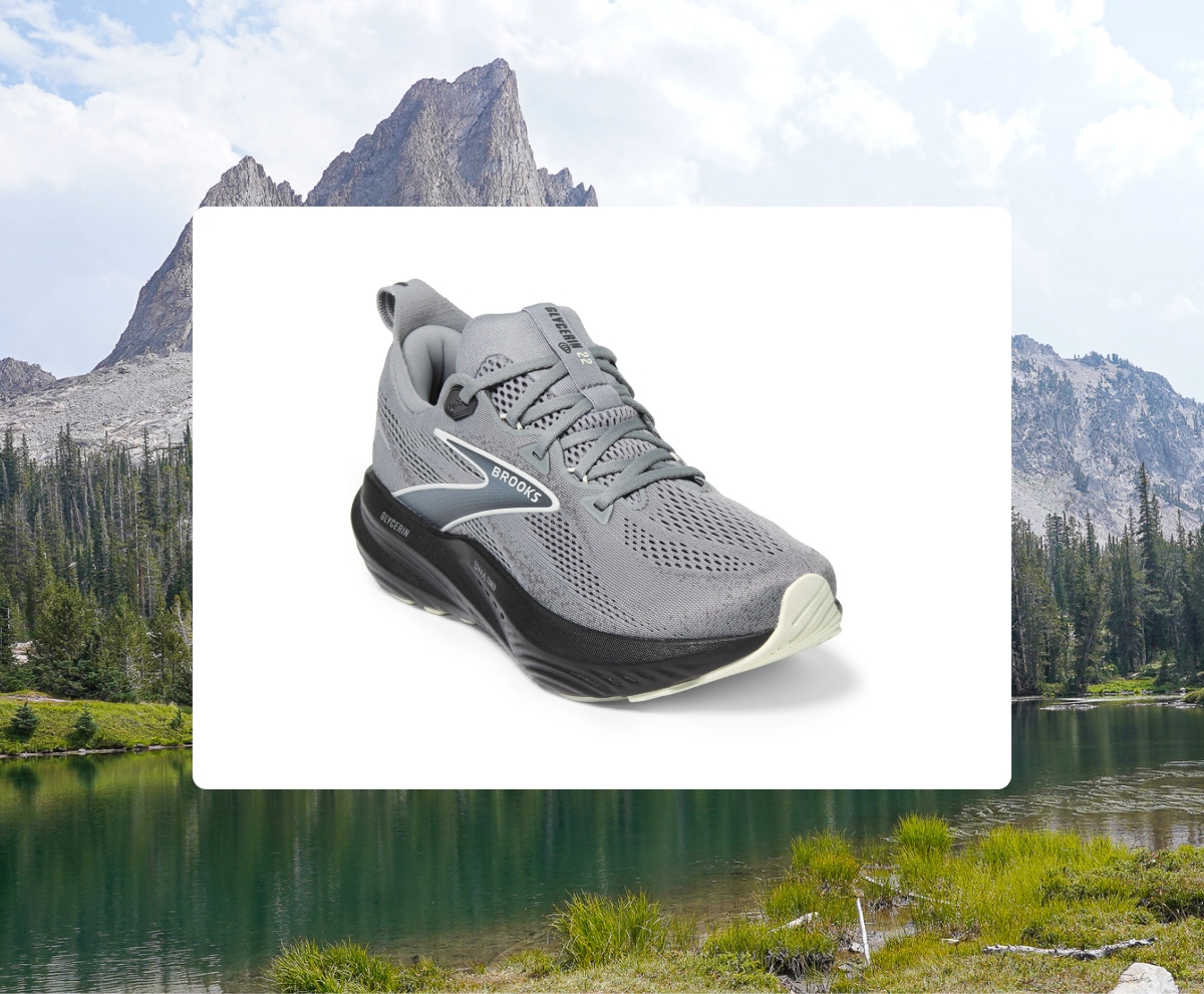 The Brooks Glycerin 22 road-running shoe over an image of a serene lake and mountain range.