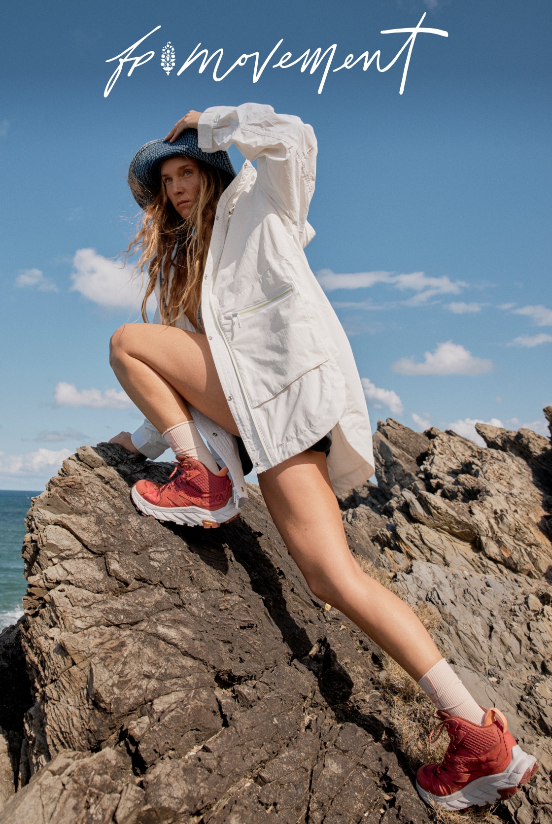 A person looks off into the distance while climbing a rocky cliffside.