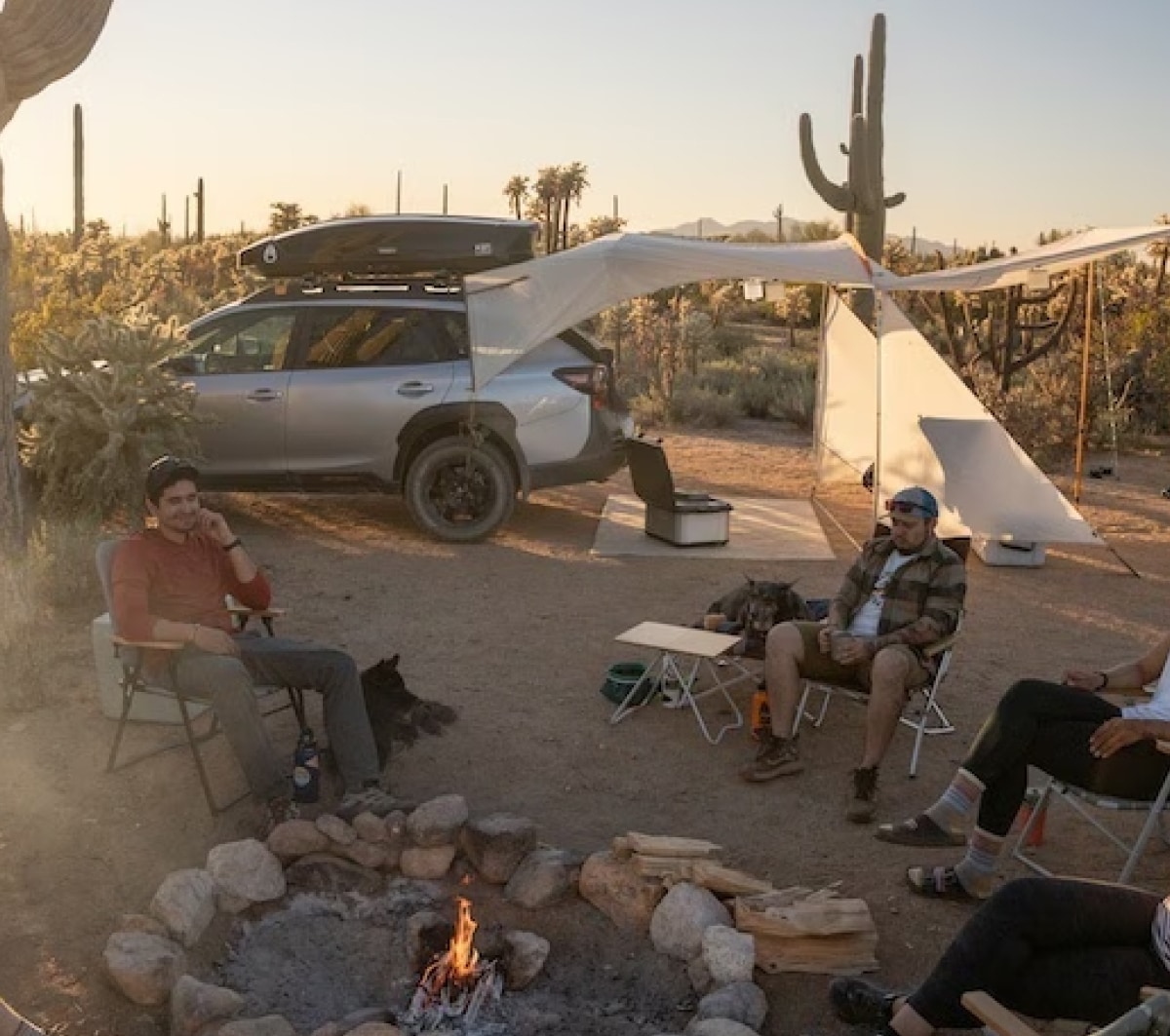 A group of people gathered around a fire at their campsite.