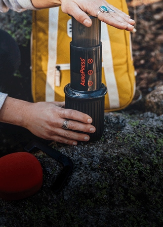 A person brews coffee with the AeroPress Go Travel coffee press