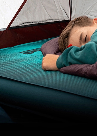 A camper rests on the NEMO Roamer Sleeping Pad