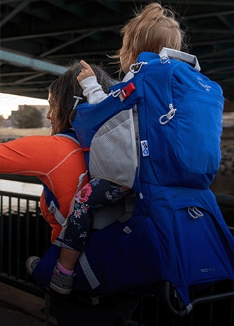 A person carries a child in the Osprey Poco Plus Child Carrier