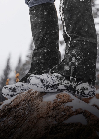 A hiker wears the Outdoor Research Crocodile GORE-TEX gaiters on a snowy trail