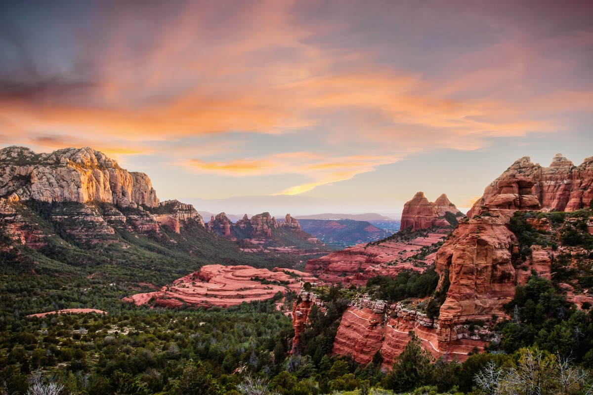 Trekking through Sedona's  geological wonders, where towering  red rock formations tell a tale of  ancient desert landscapes and  timeless beauty.