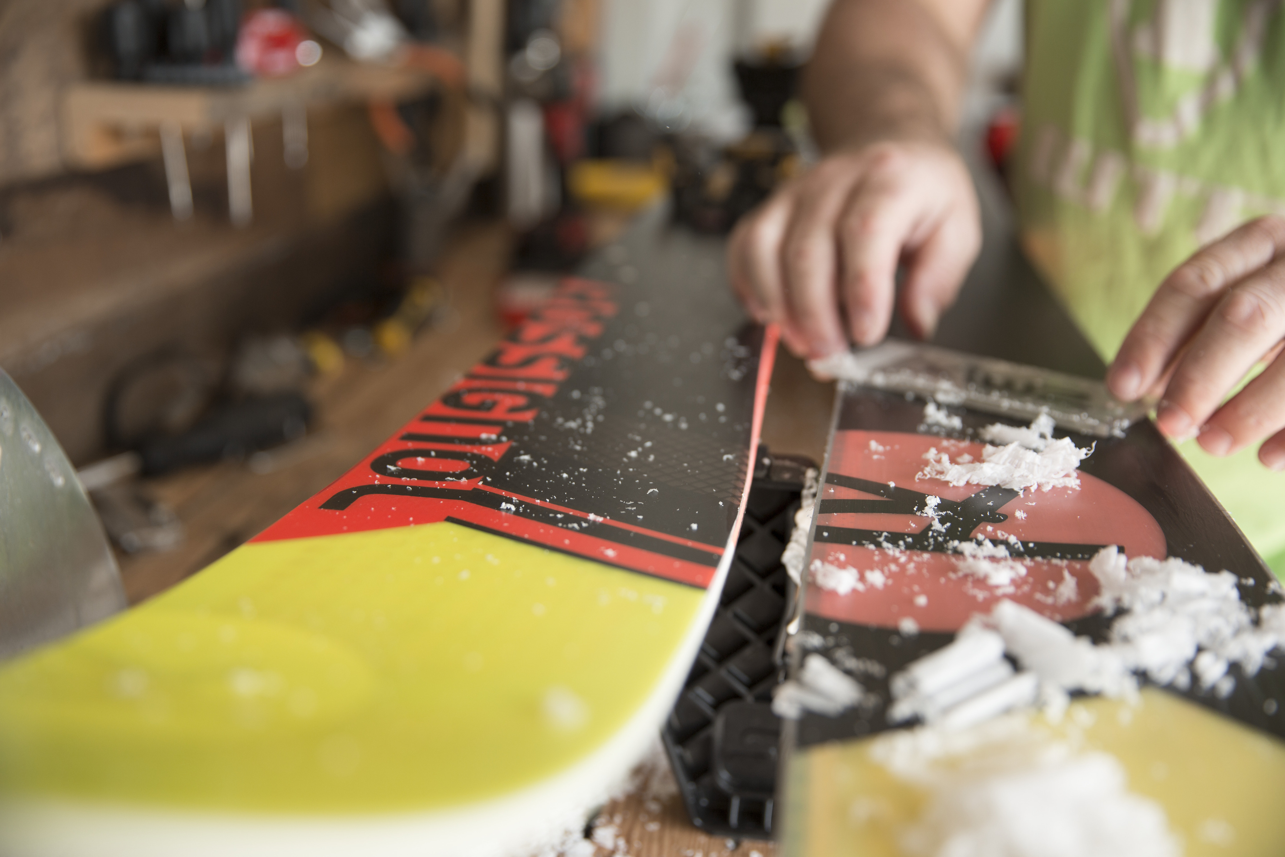 REI technician waxing a snowboard