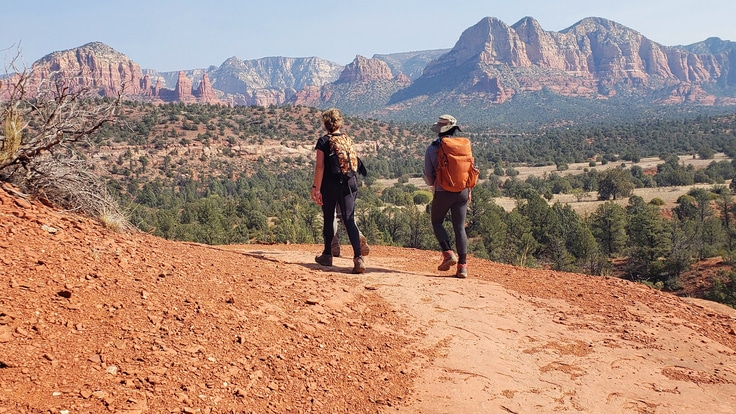 Two hikers in a mountainous desert landscape